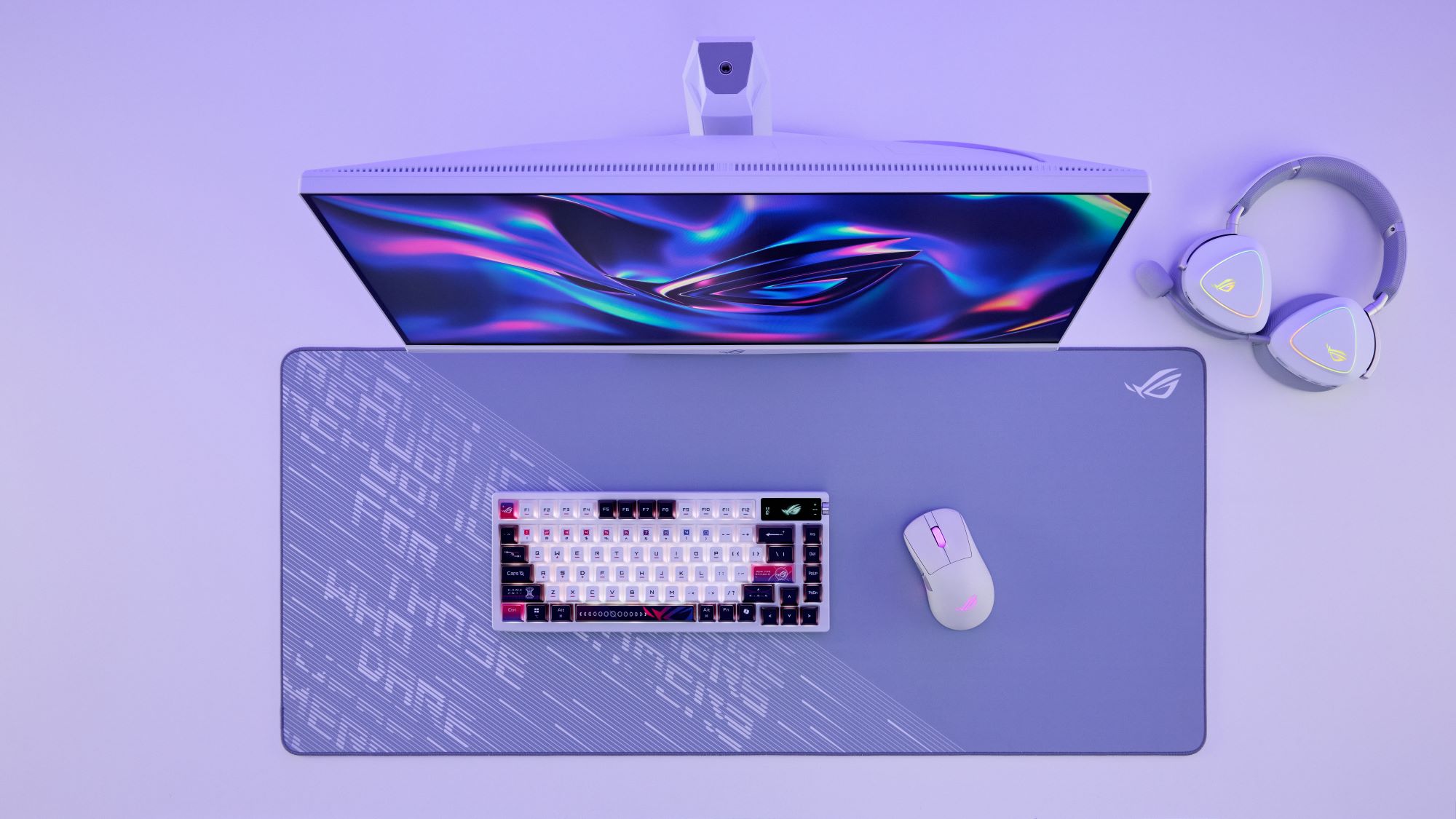 The Moonlight White ROG Delta II headset, ROG Keris II Origin mouse, ROG Azoth X keyboard, and ROG Scabbard Arctic Gray XXL desk mat on a desk, all cast in a light violet hue.